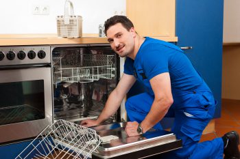 Technician or plumber repairing the dishwasher in a household